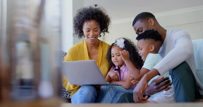 Front view of African American family using laptop in living room at home 4k