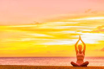 Fototapeten Yoga meditation woman meditating in lotus pose with praying hands in sunset glow on beach. © Maridav
