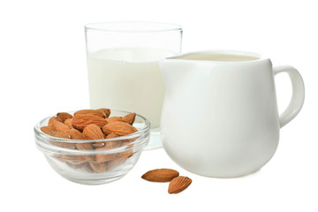 Glass of milk, milk jar and almond nuts