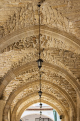 Arched gallery of chirch made of stones, with beautiful lamps, symmetry, vertical, architecture,...