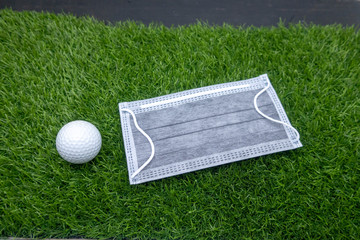 Golf ball with protection mask on green grass 