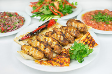 Traditional Turkish Adana Grilled chicken wings food in Turkish Restaurant with salad