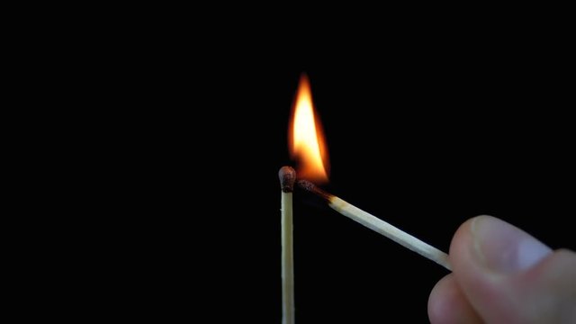 Lit Match and Flame on a Black Background and then goes out creating a Lot of Smoke
