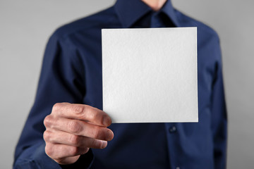 A man holding white booklet