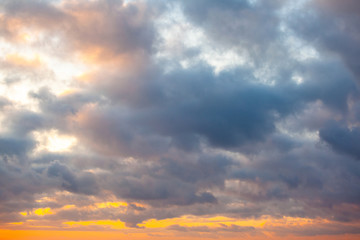 view of a warm orange sunset with clouds in pastel colors