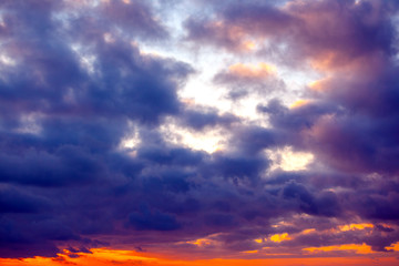 view of the bright orange sunset with purple and dark blue clouds