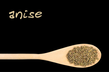 anise on wooden spoon isolated on black background. Latin name Pimpinella
