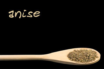 anise on wooden spoon isolated on black background. Latin name Pimpinella