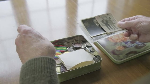 Senior caucasian man looking through a memory box themes of memories nostalgia old