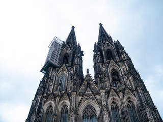 Fototapeta premium Cologne Cathedral with scaffold against cloudy sky