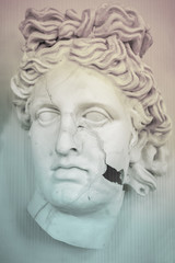 Fototapeta na wymiar Sculpture of the face of a beautiful Greek woman, in cracks. Vertical frame