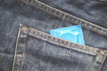 Condoms package in jeans / Colorful of Condom in pocket blue jeans on background