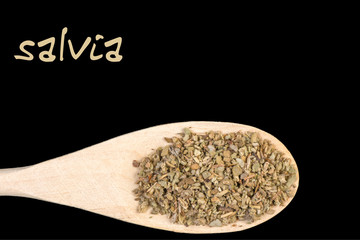 salvia on wooden spoon isolated on black background