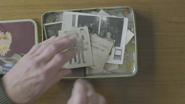 Senior caucasian man looking through a memory box themes of memories nostalgia old