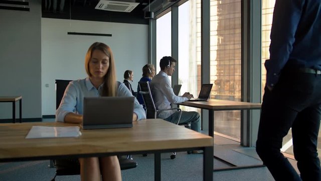 Portrait of young atractive business woman controls call-center agency.