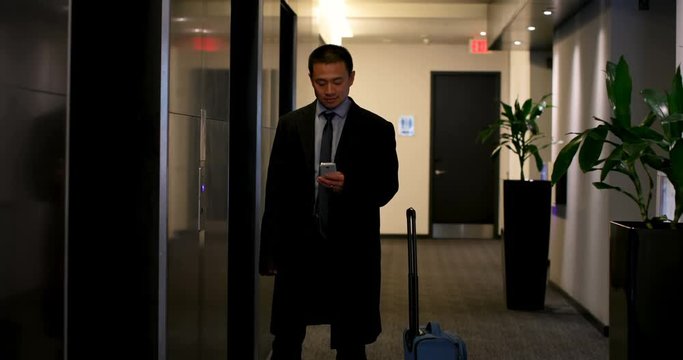 Businessman using mobile phone near elevator in a modern hotel 4k - Powered by Adobe