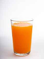 Glass of orange juice on white