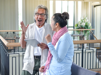 Fototapeta premium old age, technology and people concept - happy senior couple with tablet..asian elderly couple ues tablet