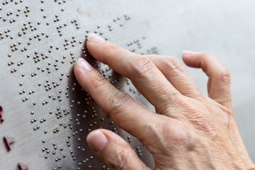 Finger reading braille tactile on public park message board - obrazy, fototapety, plakaty