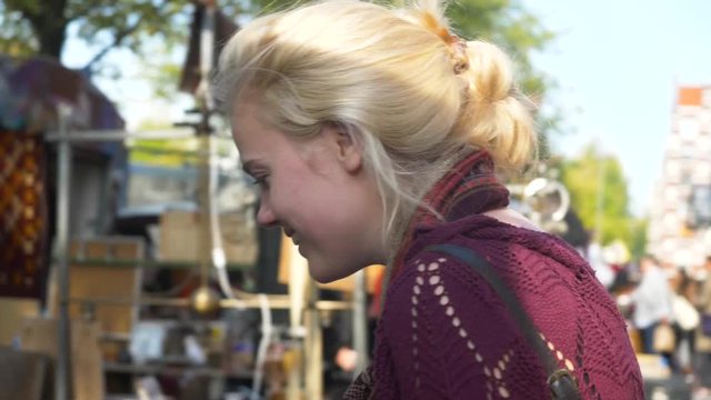 Girl walking around at European trip, tourist at market in Amsterdam, shopping around for typical dutch souvenirs