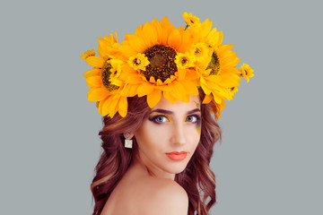 closeup portrait, confident, successful, beautiful attractive young woman in floral crown from sunflowers, posing looking at camera smiling fashion girl, isolated on grey gray background wall.