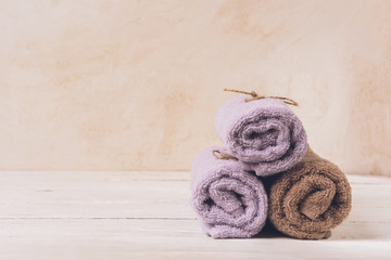 Soft clean towels laid a slide on a light background. Copy space. Selective focus.