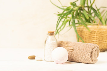 Fototapeta na wymiar Set for spa treatments. Soft clean towels bath salt piece of natural soap laid light wooden background. Copy space.
