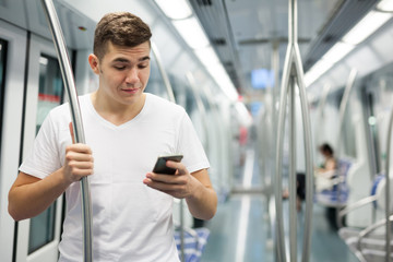 Fototapeta na wymiar Man using phone in underground carriage