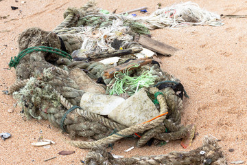 Flotsam and jetsam washed up on a sandy beach in Asia