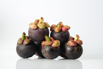 Mangosteen, an exotic asian fruit isolated on white with reflection.