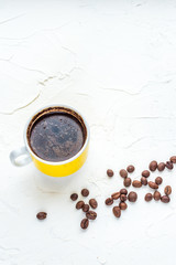 Coffee yellow cup and beans on a white background. Vertical photo