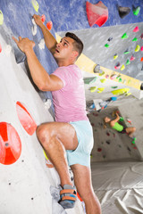 Male practicing on artificial boulder without safety belts