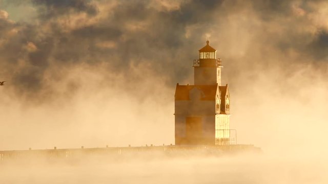 Lonely lighthouse in beautiful subzero steaming lake at sunrise, heatwaves rippling as the fog rises.