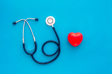 Heart health, health care concept. Stethoscope near rubber heart on blue background top view space...