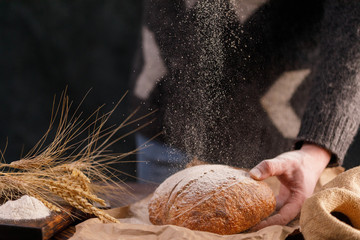 Bread on a wooden board and spikelets. The concept of healthy food and traditional bakery.
