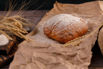 Craft bread and spikelets on burlap closeup. The concept of healthy food and traditional bakery.