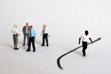 Miniature people. The concept of racial discrimination within the organization. - obrazy, fototapety, plakaty