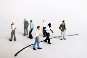 The concept of racial discrimination in society. Miniature people divided into black borders.