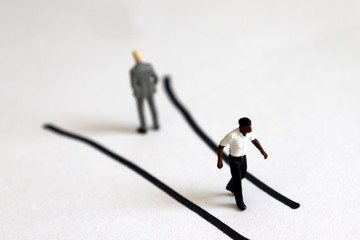 Miniature people walking in different directions.