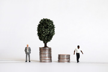 Miniature people. The concept of racial wage disparity. - obrazy, fototapety, plakaty