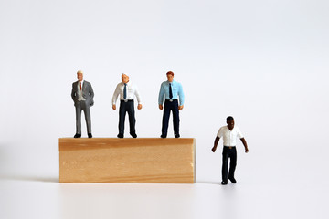 Miniature people standing on tree blocks and miniature man standing under tree blocks. The concept...