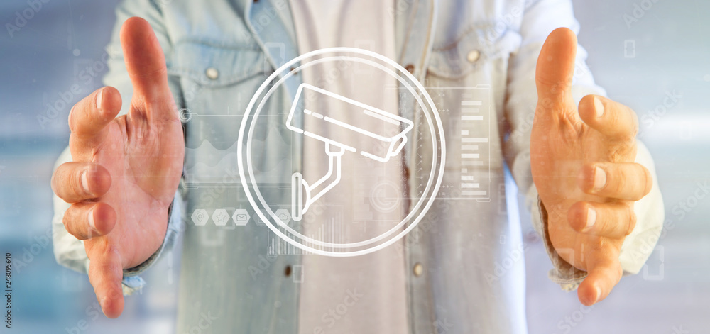 Poster businessman holding security camera system icon and statistics data - 3d rendering