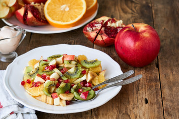 Salad with various fresh fruits on a white plate   