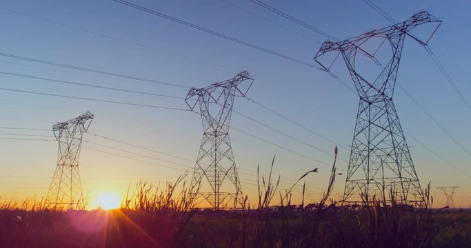 Time lapsed of electricity pylon on a field during sunset 4k