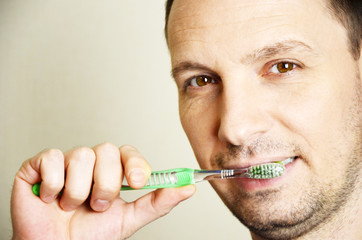 young man brushing his teeth