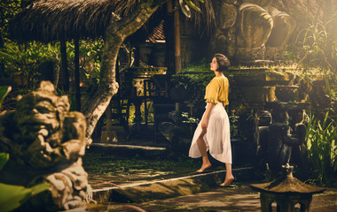 A girl in a white dress. Travel to Bali. Authentic architecture. Travel.