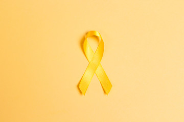 Childhood Cancer Awareness Yellow Ribbon on yellow background.