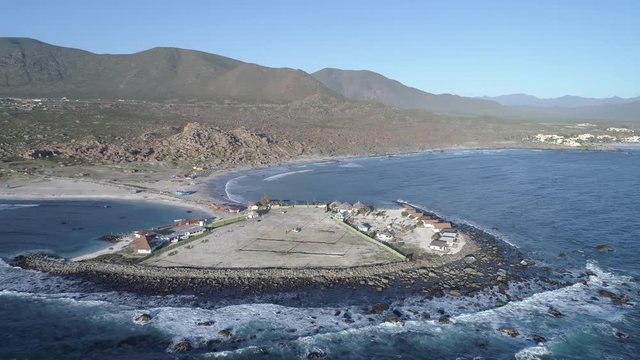 Aerial Footage. Totoralillo beach at Coquimbo region in north Chile at Atacama Desert an amazing wild beach with a nice peninsula, cottages, surf and awe cloudy colorful sunsets. Atacama Desert 3/6
