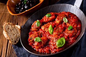 Baked mini meatballs in tomato sauce with basil