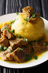 Mofongo (Garlic-Flavored Mashed Plantains) a dish with pork rind served with meat and broth...